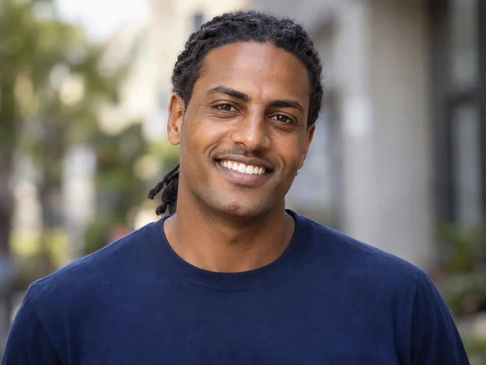AI-generated illustrative portrait of a clean-shaven man wearing a navy crewneck; not a photograph of Daniel K.